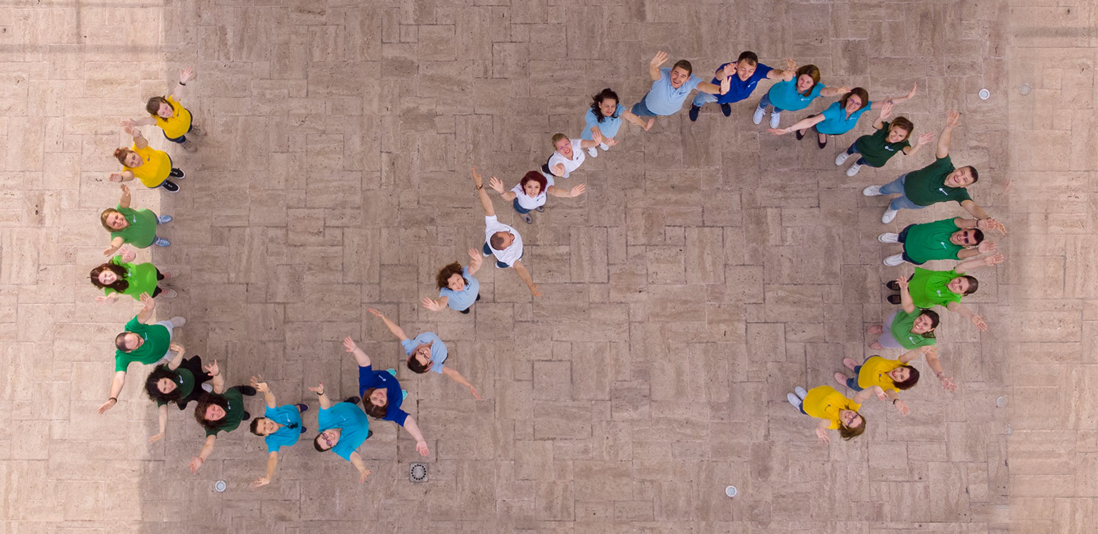 SmartBill team forming the S-shaped symbol, photographed from above